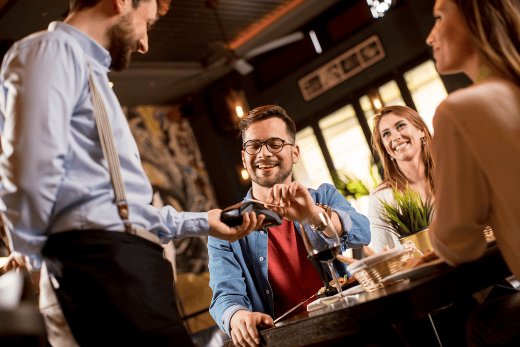 Waiter taking payment at table